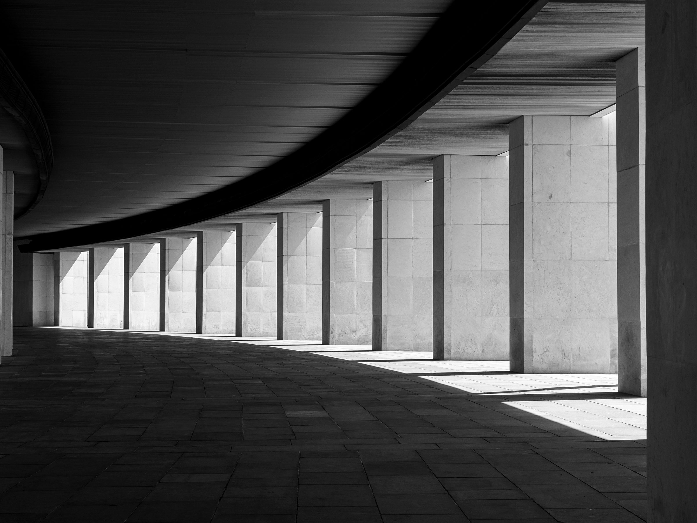 A sweeping curved colonnade — representing the continuity and scale of institutional connectivity.